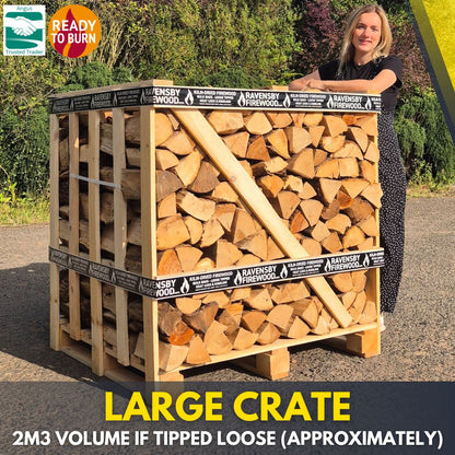 Woman standing next to a large crate of kiln-dried fire wood logs with 'Ravensby Firewood' branding.
