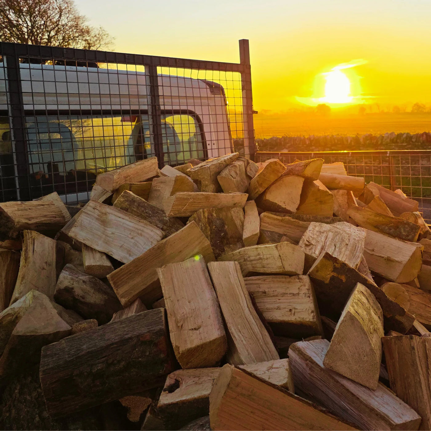 Stack of dry firewood sticks with a sunset in the background on way to a delivery in Arbroath, Angus