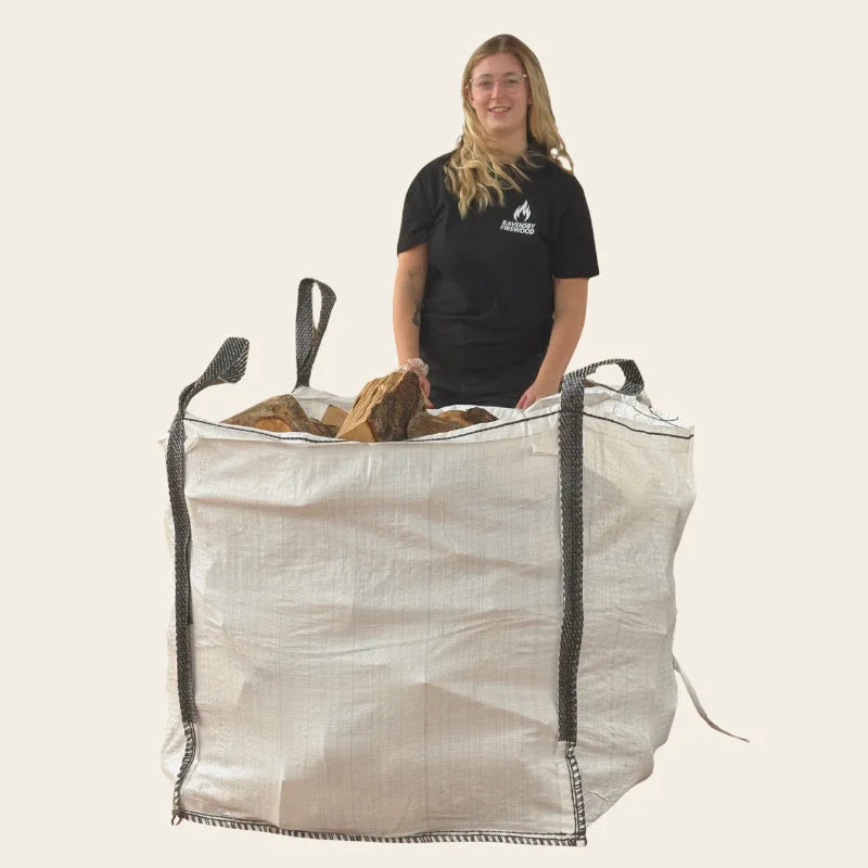 Woman standing next to a builders tonne bag of firewood logs in Dundee