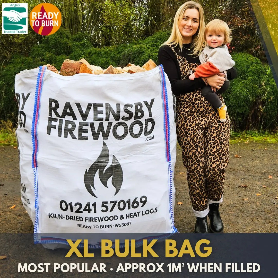 Woman holding a child next to an XL bulk bag of kiln-dried firewood logs with promotional text saying Ravensby Firewood.